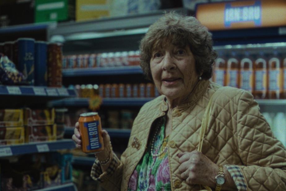 Woman holding Irn-Bru in shop